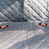 1568779012824.jpg Close-up of dark quilted fabric with two red plastic buckles along a seam.