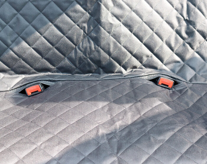 1568779012824.jpg Close-up of dark quilted fabric with two red plastic buckles along a seam.